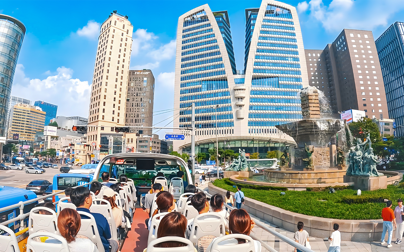 Open-top bus tour passing by Dongdaemun landmarks in Seoul.