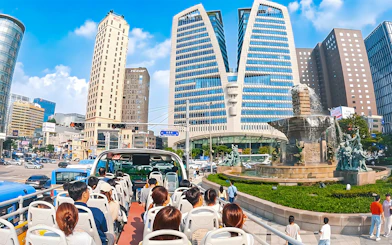 Open-top bus tour passing by Dongdaemun landmarks in Seoul.