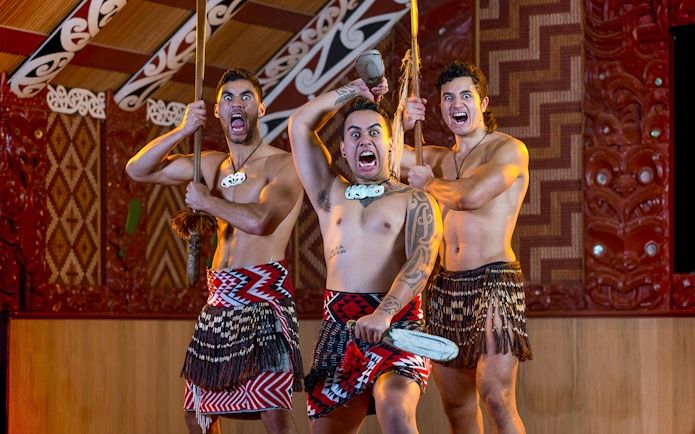 Maori performers in traditional attire during a haka at Te Puia, New Zealand.