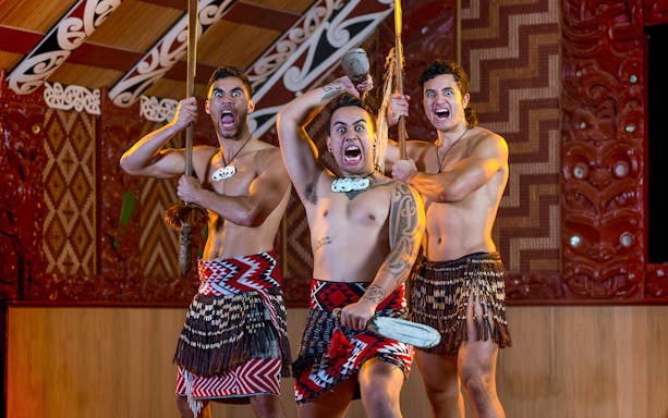 Maori performers in traditional attire during a haka at Te Puia, New Zealand.