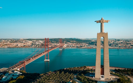 Helicopter view of Lisbon's Christ the King statue and 25 de Abril Bridge.