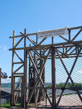 Entrance gate of Natzweiler-Struthof concentration camp under a clear sky.