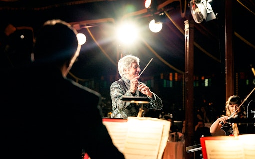 Conductor leading orchestra at Strauss concert in Prater Vienna.