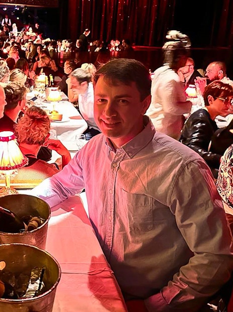 Couple enjoying champagne at a table during the Moulin Rouge show in Paris.