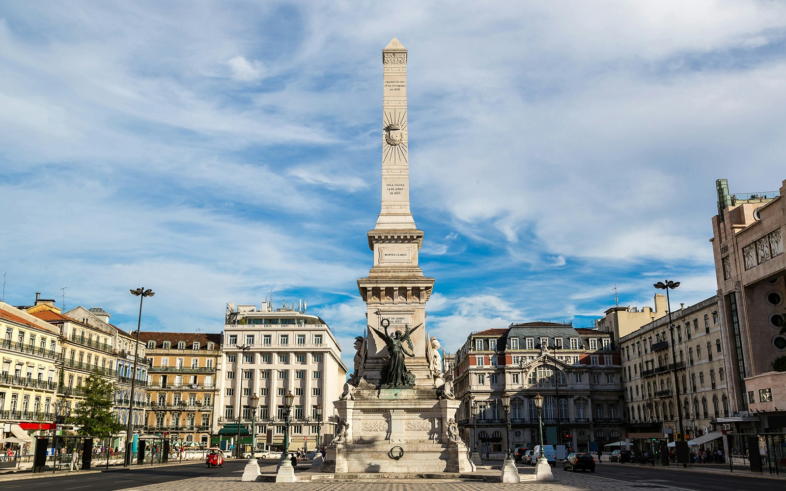 Obelisk monument at Restauradores Square, Lisbon, surrounded by historic buildings.