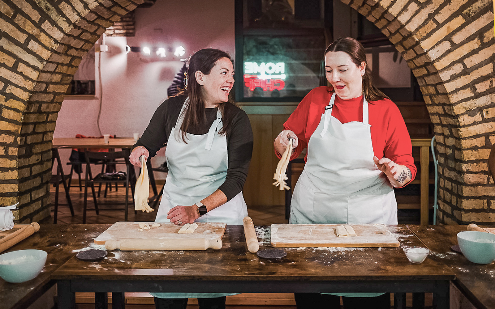Two people making pasta in a cooking class in Rome.
