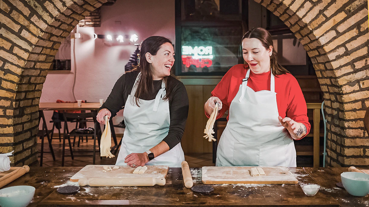 Two people making pasta in a cooking class in Rome.