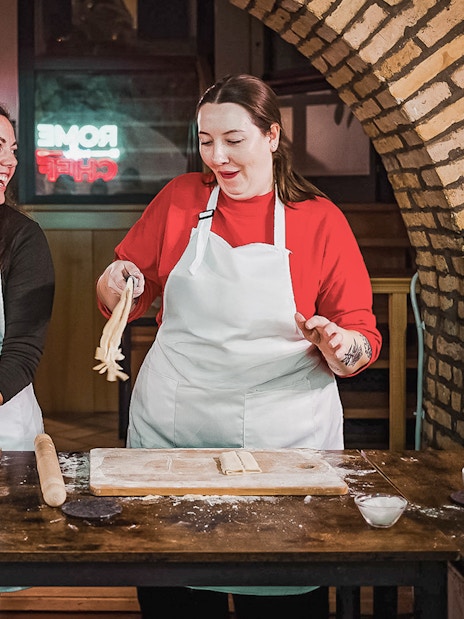 Two people making pasta in a cooking class in Rome.