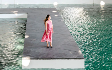 Person standing on a platform by water at Louvre Abu Dhabi.