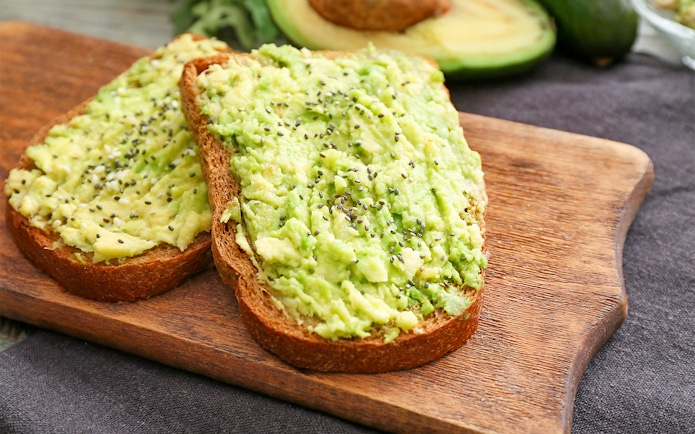Avocado toast with chia seeds on wooden board