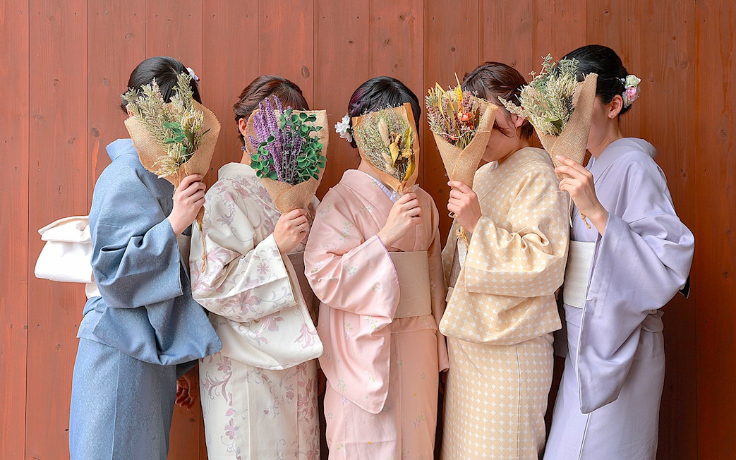 Women in kimonos holding bouquets in Gion, Kyoto.