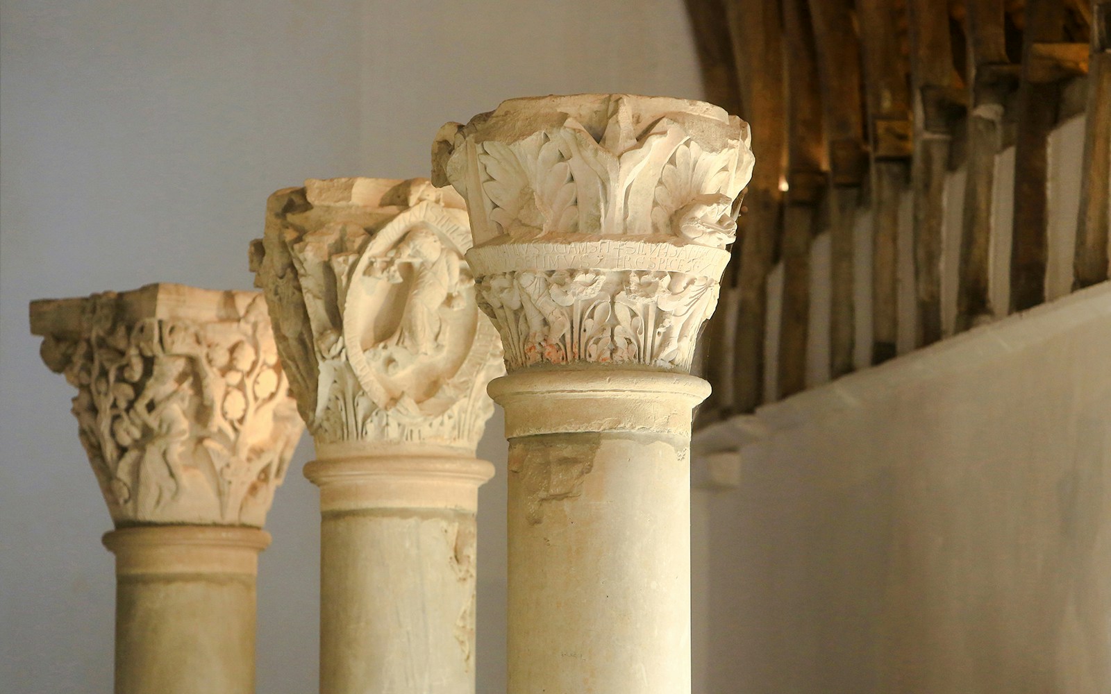 Stone columns with intricate carvings at Abbaye de Cluny, Lyon, France.