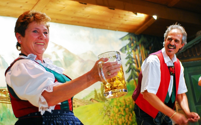 Tyrolean performers in traditional attire during a folk show in Innsbruck, Austria.