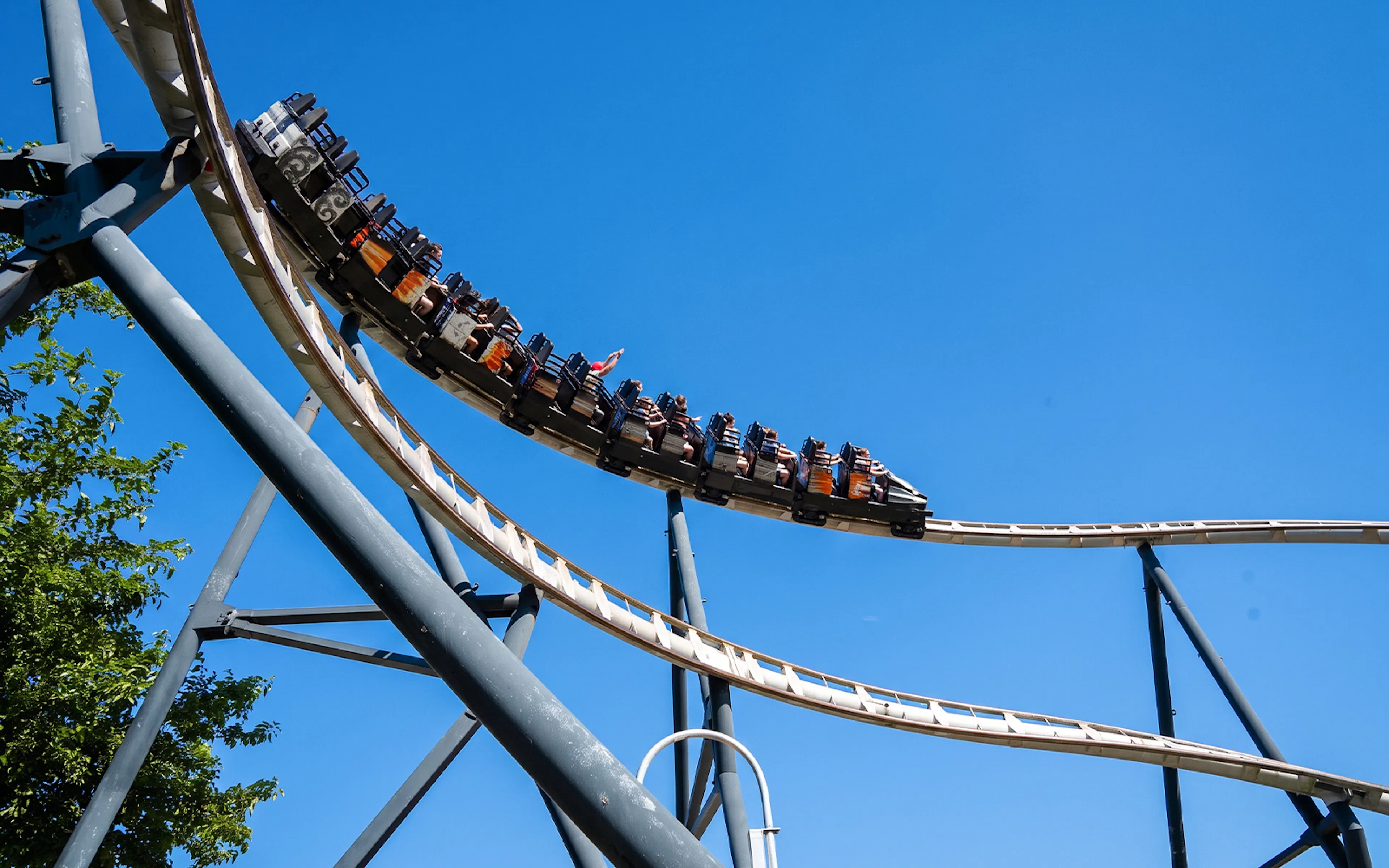 Roller coaster on Silver Bullet ride at Frontier City against blue sky.