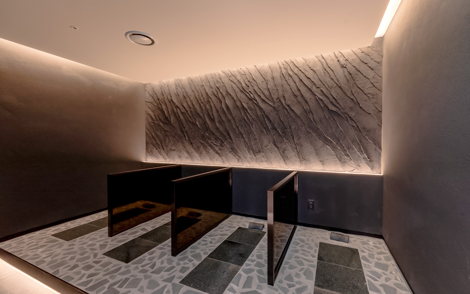 Private shower stalls in the spa at Club D Oasis with textured walls.