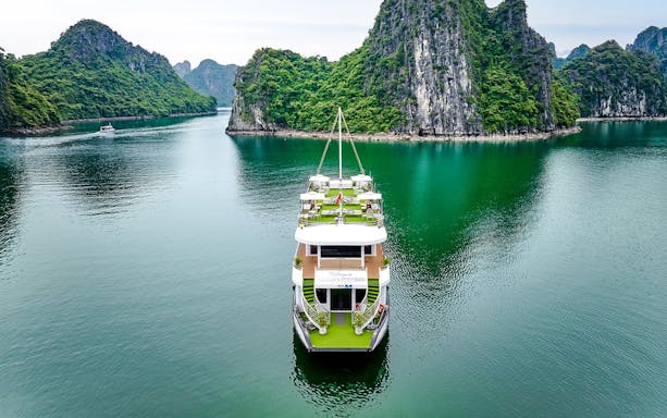 Cruise ship Hercules Premium sailing through limestone karsts in Halong Bay, Vietnam.