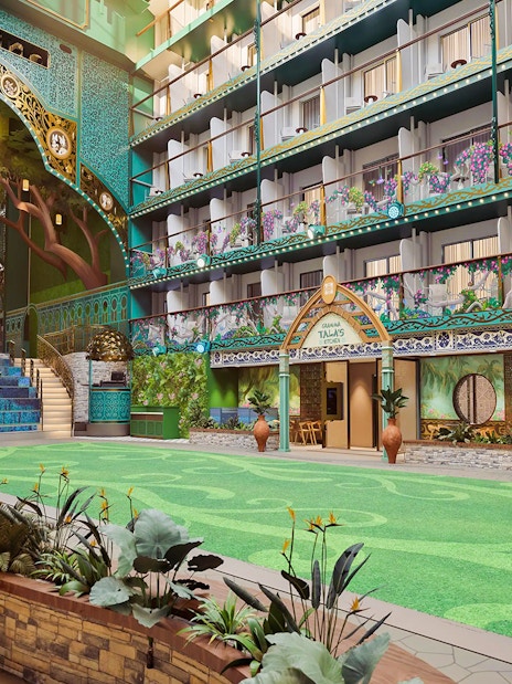 Disney Imagination Garden atrium with vibrant murals and lush greenery on Disney Adventure Cruise.