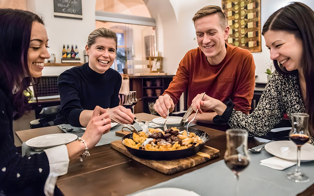 Participants enjoying Kaiserschmarrn at a dining table.