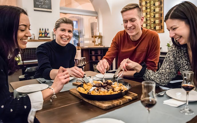 Participants enjoying Kaiserschmarrn at a dining table.