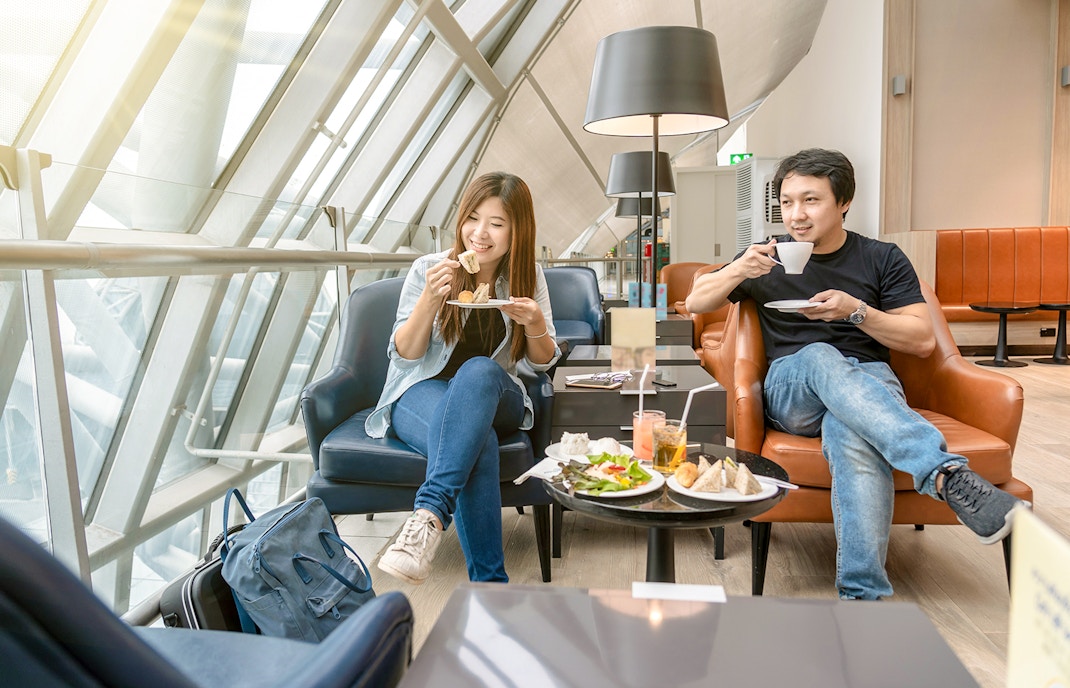 Travelers enjoying refreshments at Narita International Airport lounge.