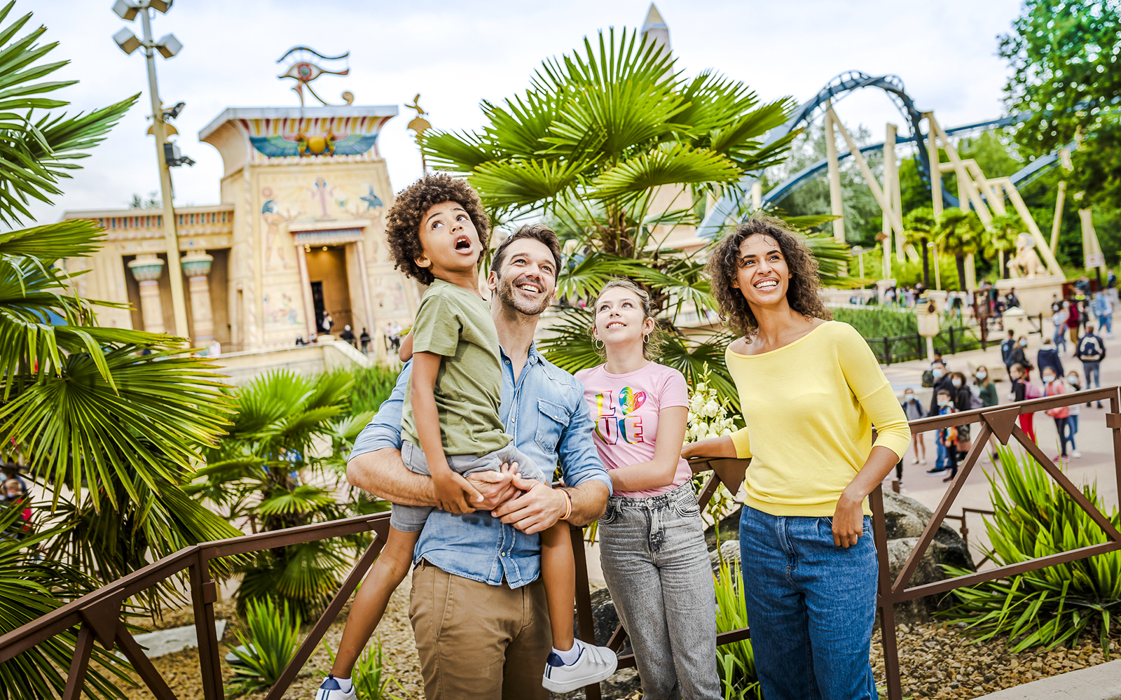 Family enjoying a day at Asterix Park with Egyptian-themed attractions in the background.