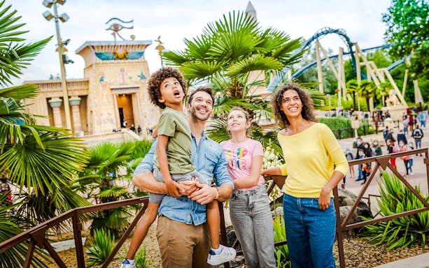 Family enjoying a day at Asterix Park with Egyptian-themed attractions in the background.