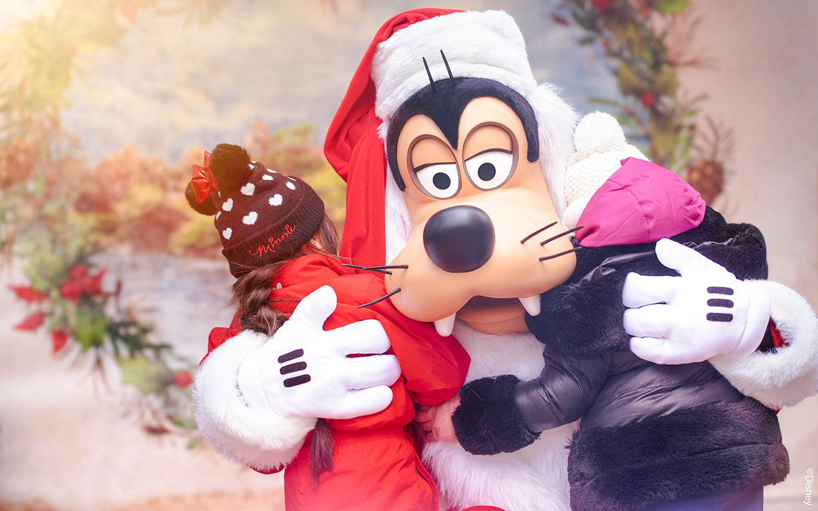 Goofy hugging children at Disneyland during Christmas 2025 celebrations.