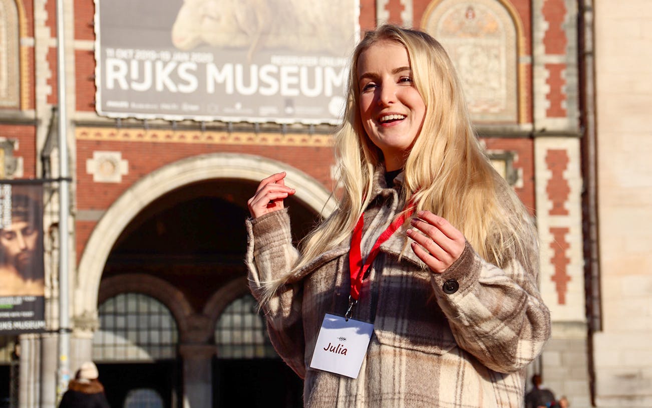 Tour guide in front of Rijksmuseum, Amsterdam, for art history tour.