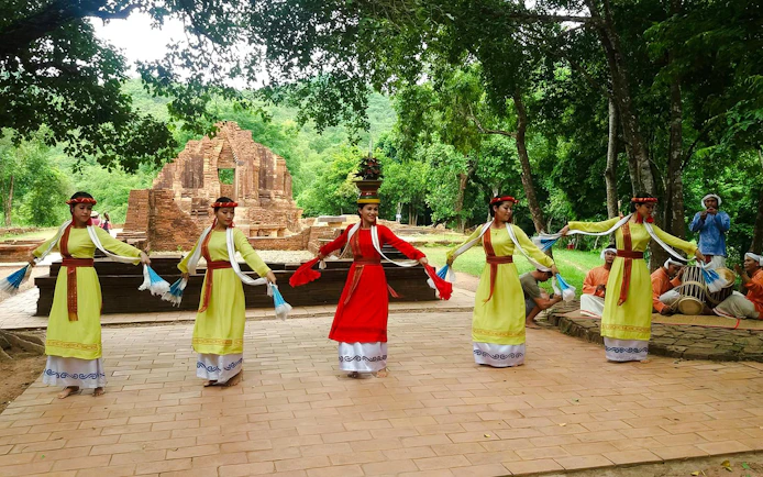 Traditional Cham dance at My Son Sanctuary, Vietnam, with ancient temple ruins in the background.