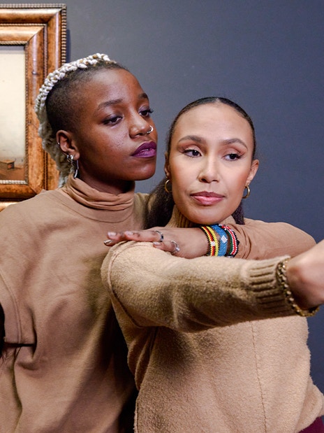 Visitors taking a selfie with Vermeer's "The Milkmaid" painting in the background.