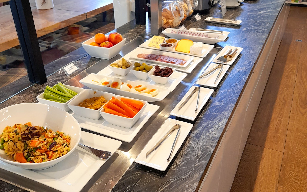 Buffet spread with fruits, salads, and snacks at Plaza Premium Lounge.
