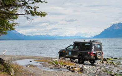 4x4 vehicle by Lake Fagnano shoreline during off-road tour, Tierra del Fuego.