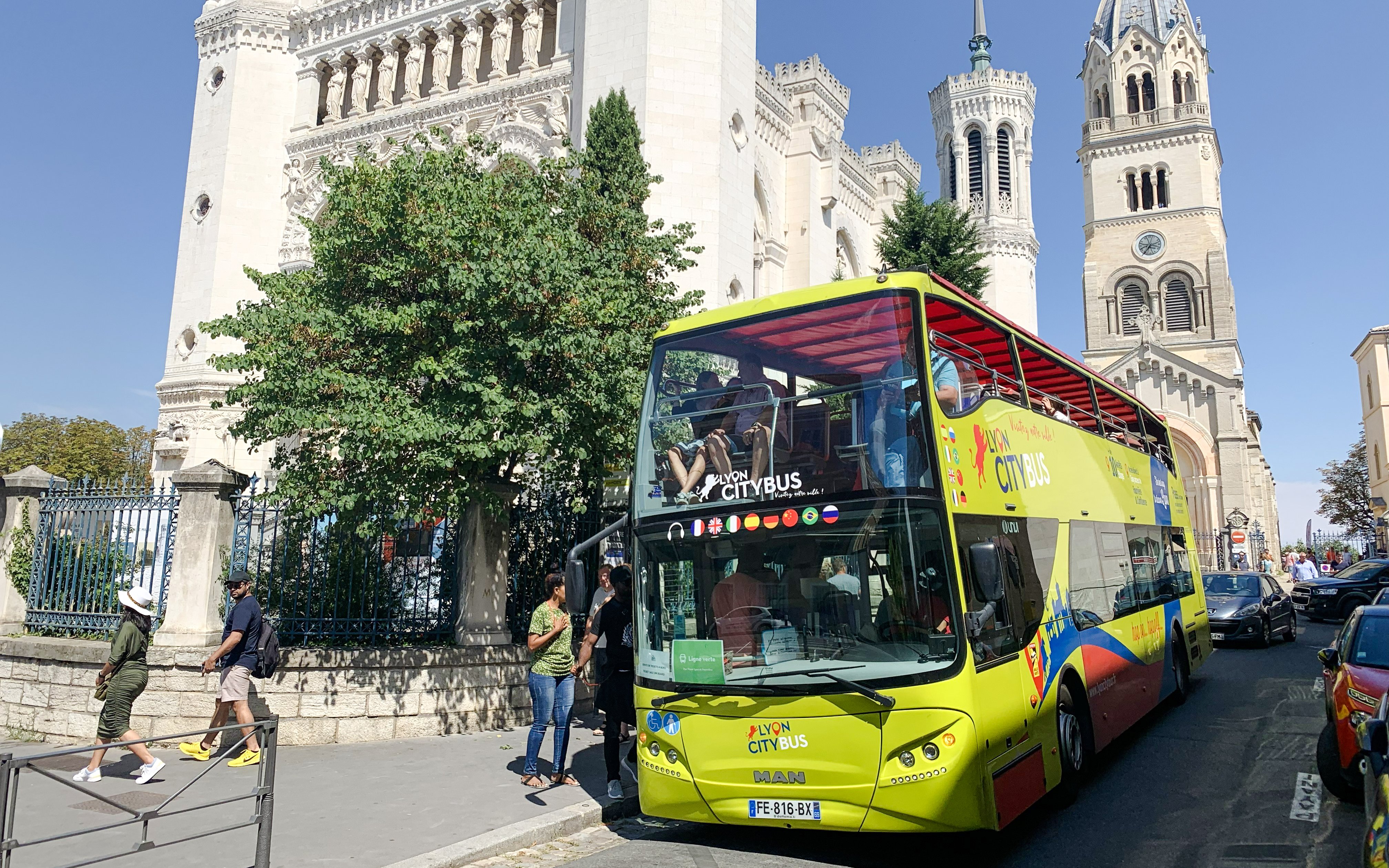 Open-top Lyon city tour bus near Basilica of Notre-Dame de Fourvière, France.