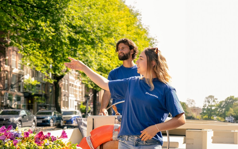 Guides on Amsterdam canal cruise boat with flowers and life preserver