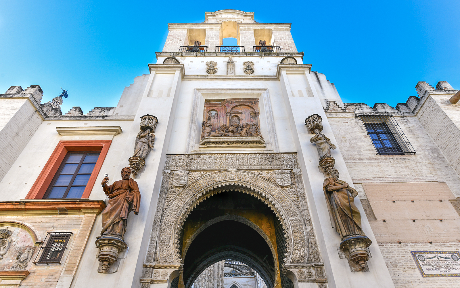 Seville Cathedral's Door of Forgiveness with ornate carvings and statues.