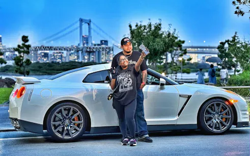 Tokyo skyline with a Nissan GT-R R35 and two people posing for a photo.