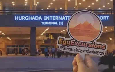 Hurghada International Airport entrance with EgyExcursions sign in foreground.