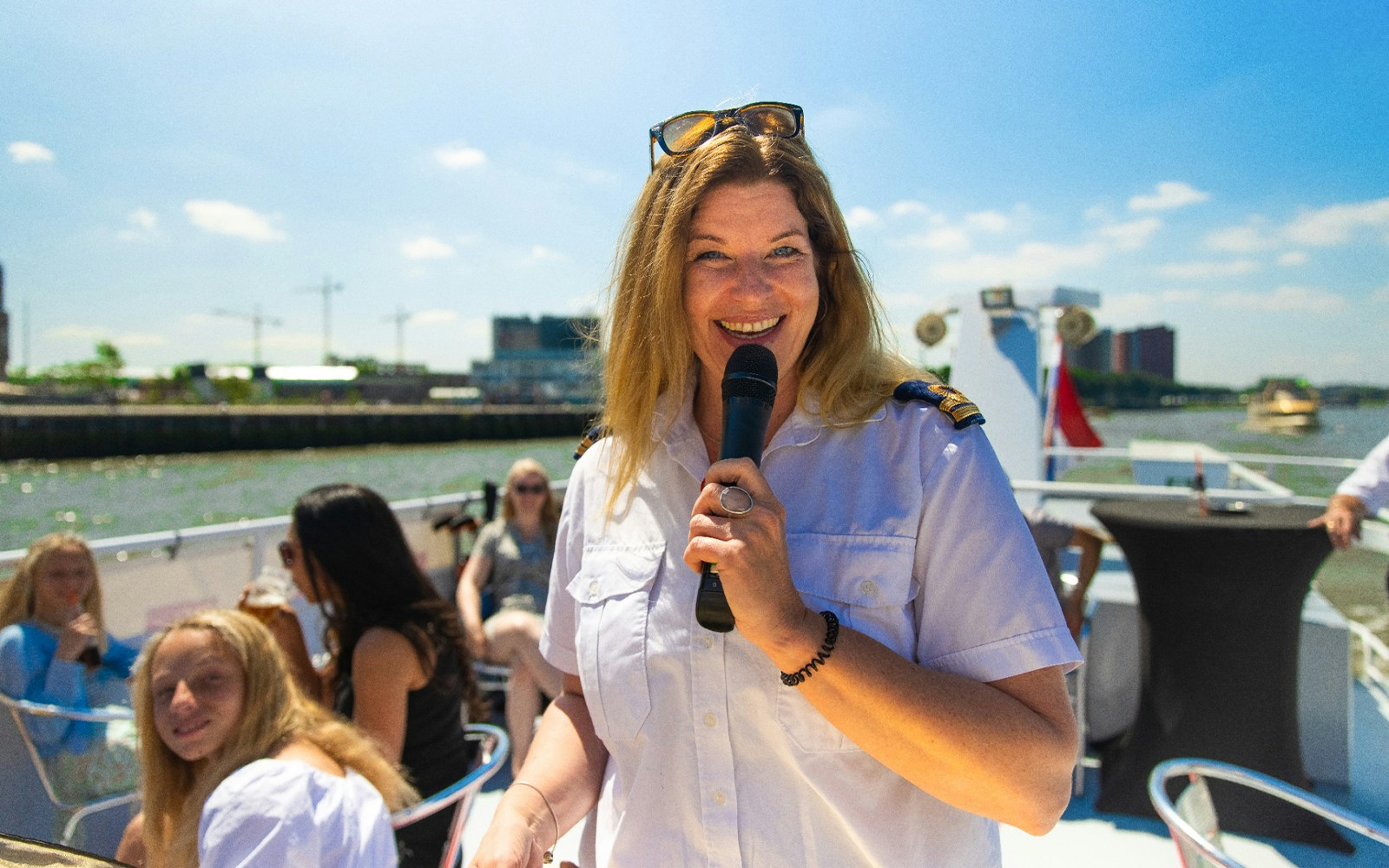River cruise in Rotterdam with live guide, showcasing city skyline and iconic Erasmus Bridge.