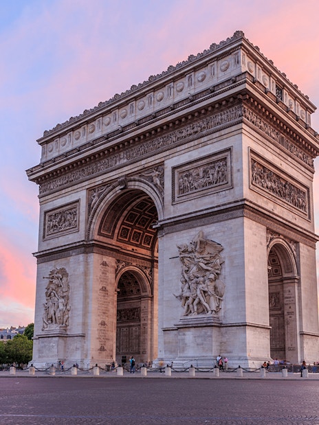 Arc de Triomphe in Paris with a colorful sunset sky.