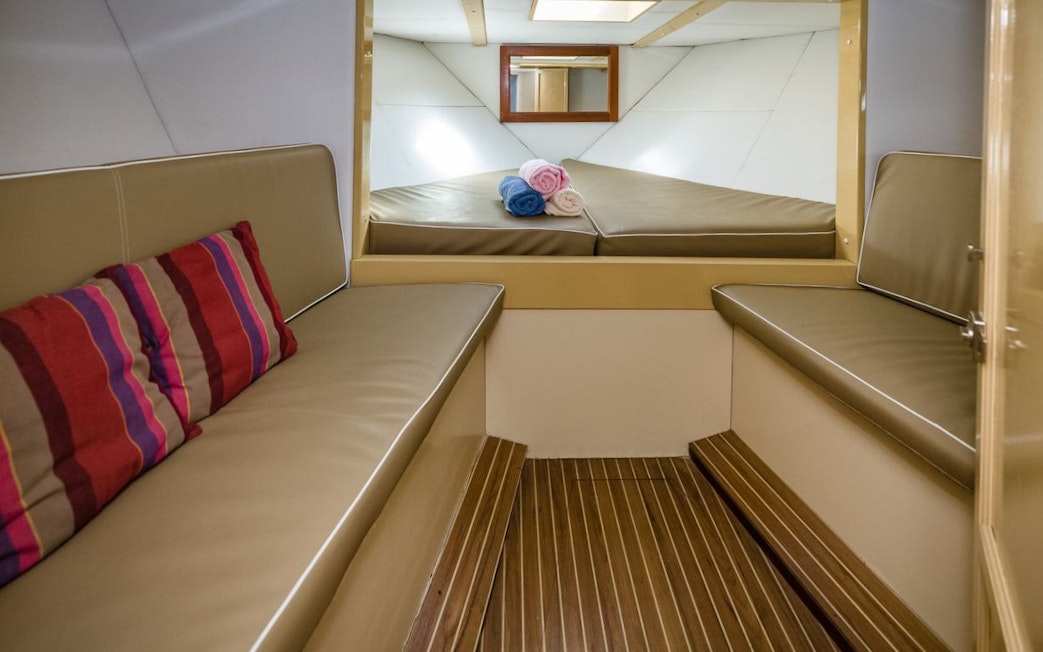 Interior of shared yacht cabin with seating and towels, Tenerife whale and dolphin watching tour.