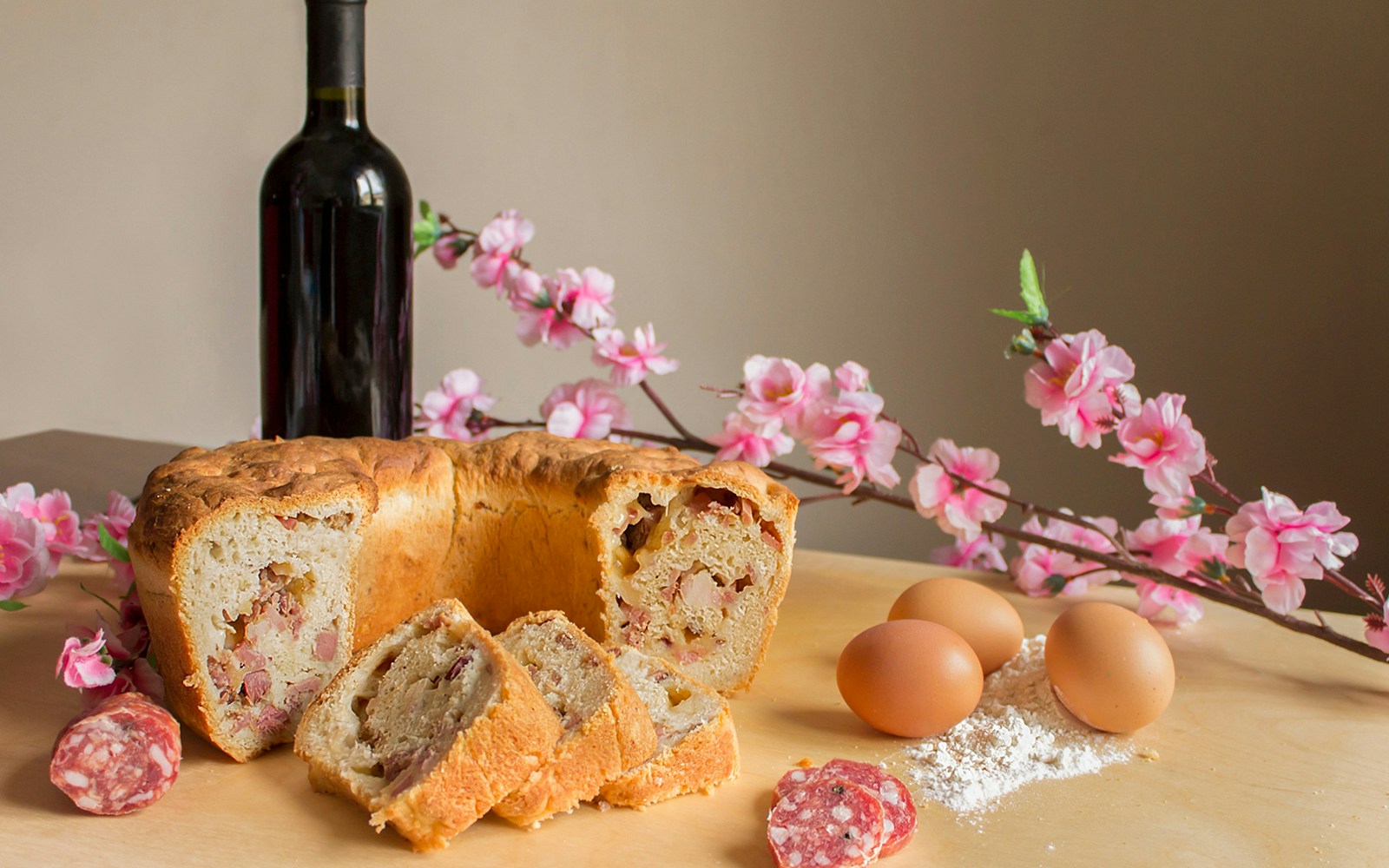 Casatiello Napoletano bread with salami and cheese on a wooden table in Naples, Italy.