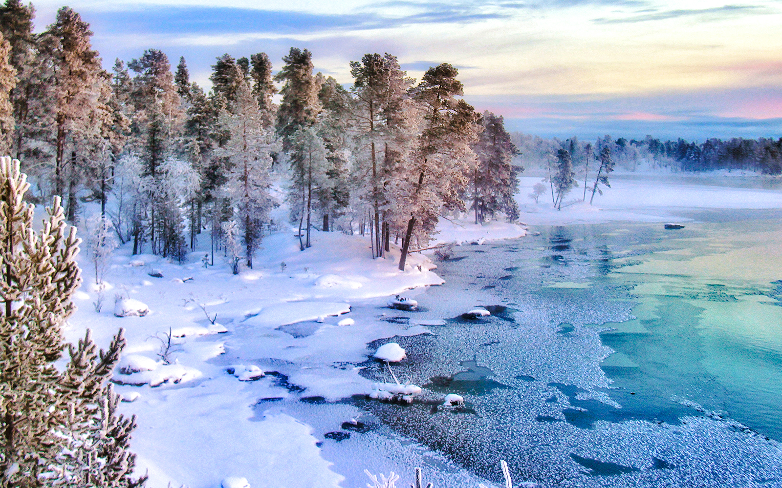 Frozen lake surrounded by snow-covered trees in Lapland.