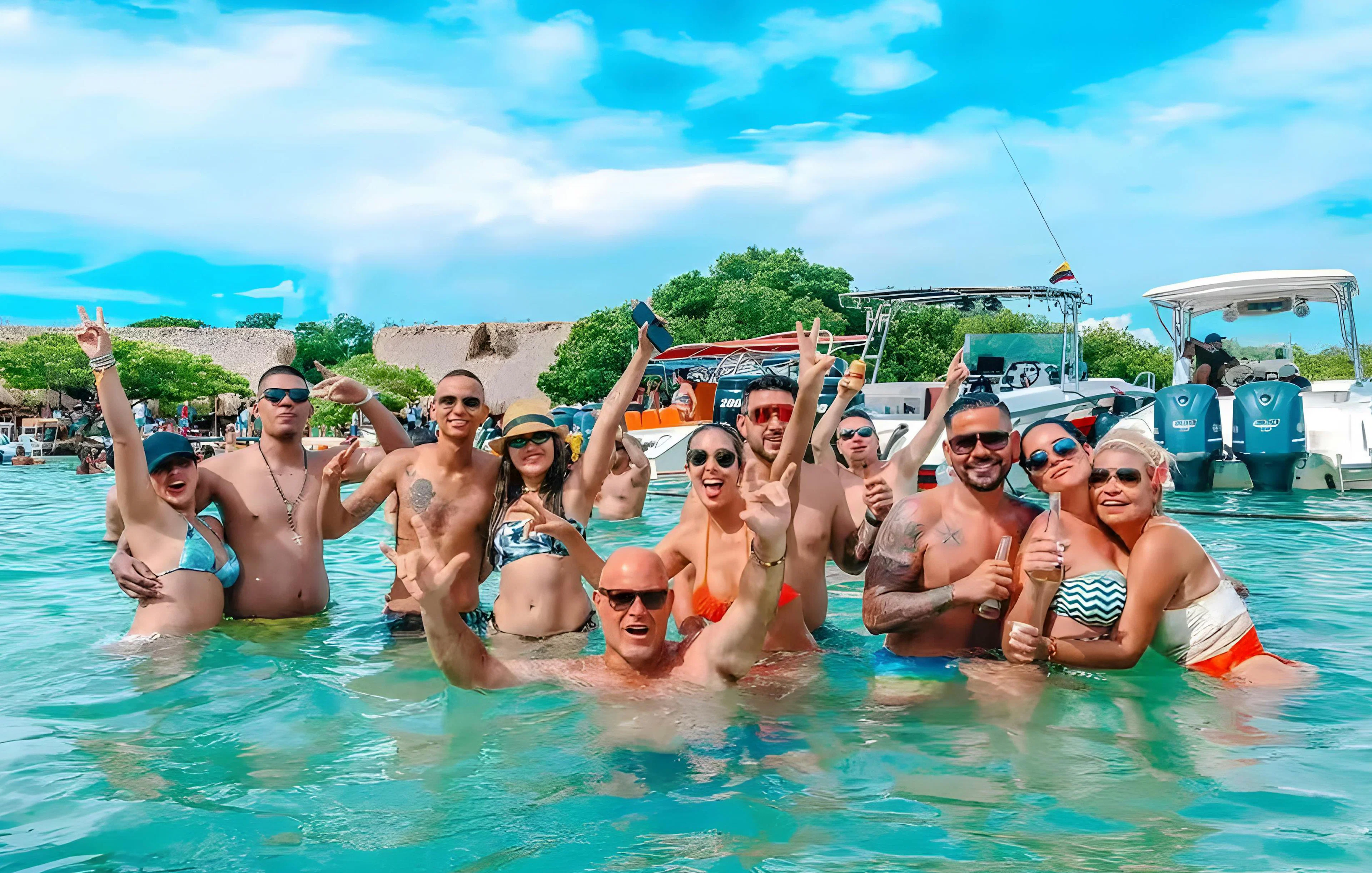 Tourists enjoying the water at Rosario Islands, Cartagena, Colombia with boats in the background.