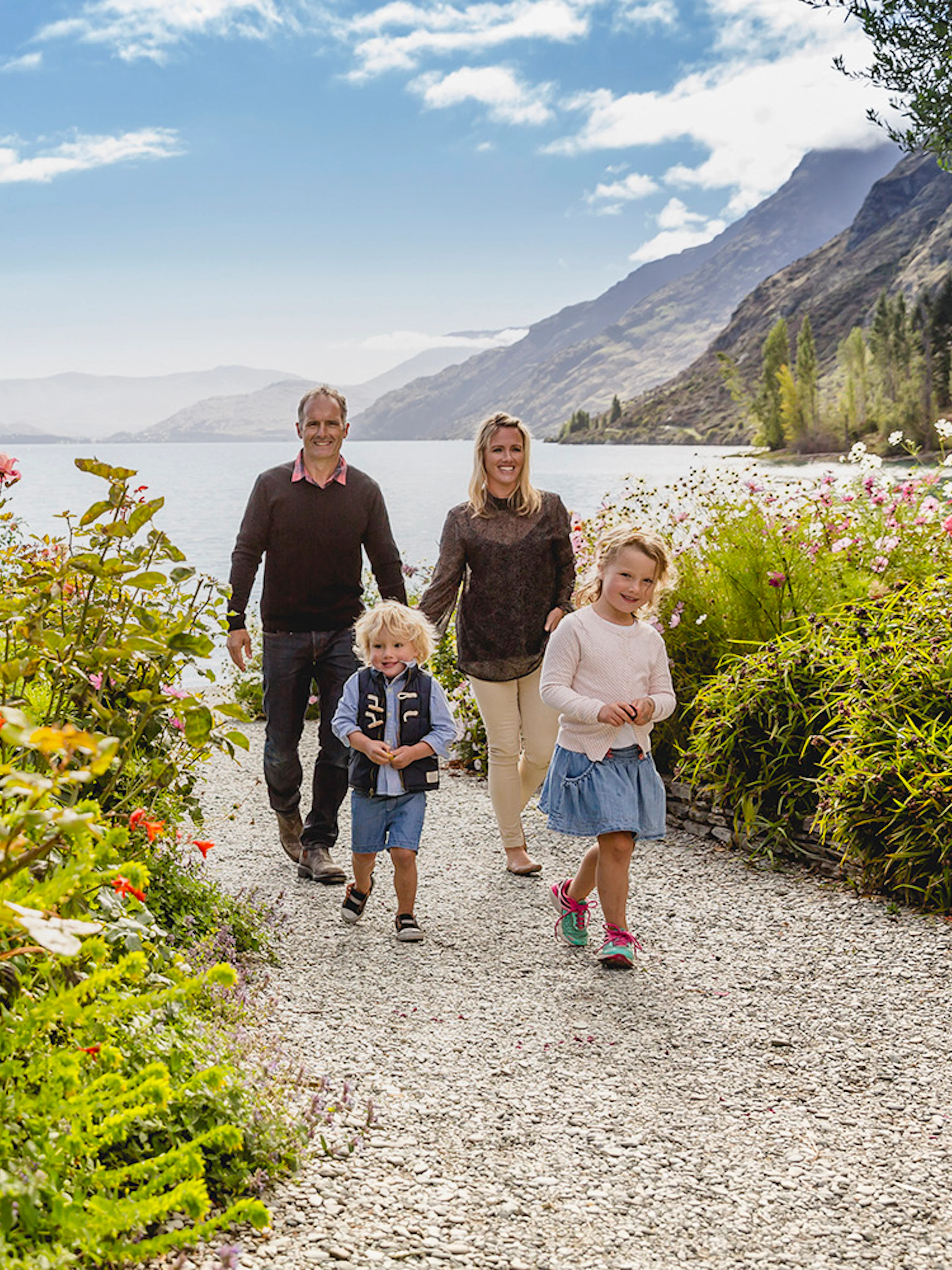 Family walking through flower garden at Walter Peak High Country Farm, New Zealand.