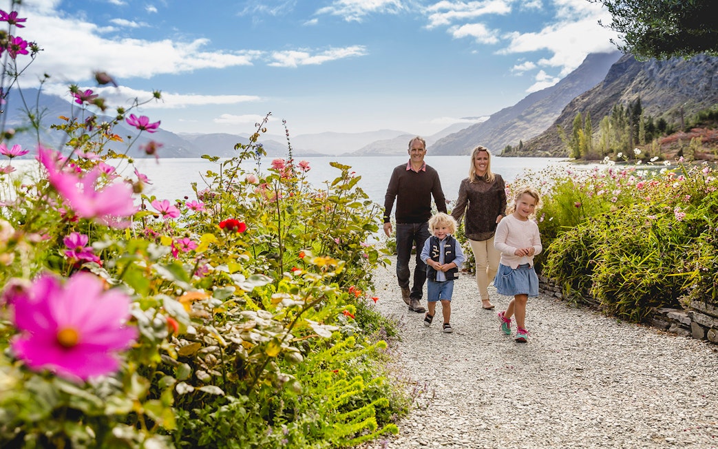 Family walking through flower garden at Walter Peak High Country Farm, New Zealand.