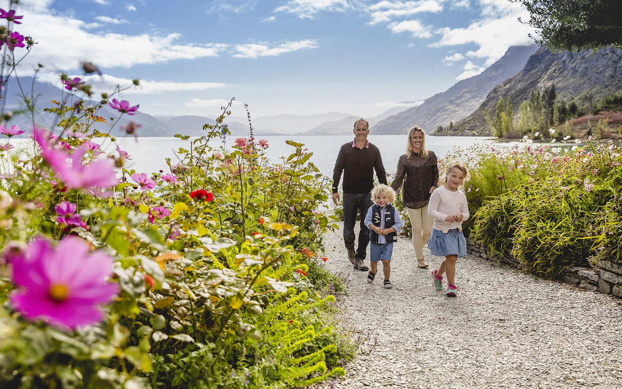 Family walking through flower garden at Walter Peak High Country Farm, New Zealand.