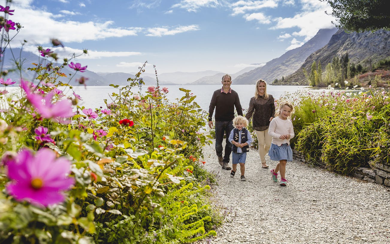 Family walking through flower garden at Walter Peak High Country Farm, New Zealand.
