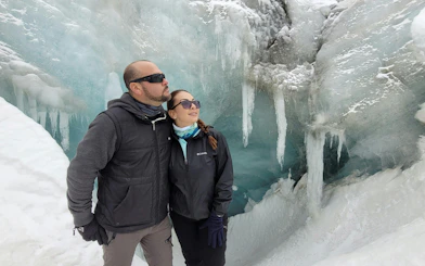 Couple exploring ice formations on Vinciguerra Glacier trek, Argentina.