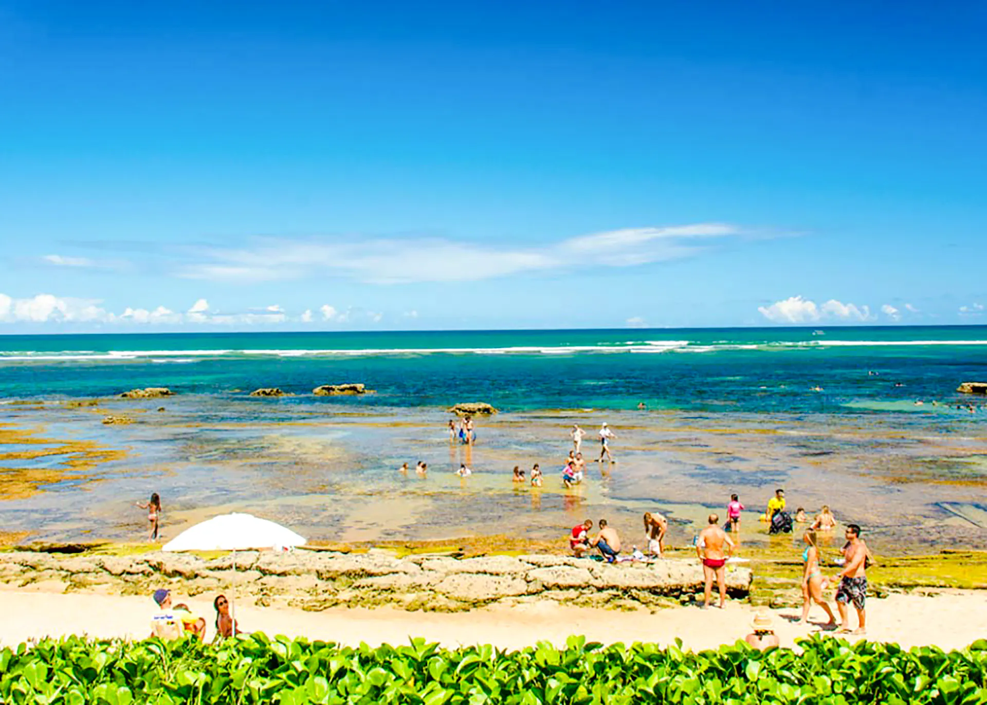 Beachgoers enjoying the tide pools at Arraial d'Ajuda, Porto Seguro.