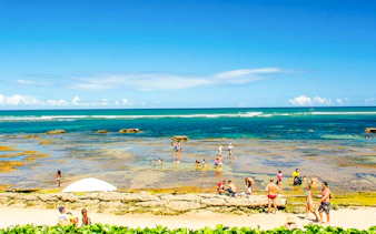 Beachgoers enjoying the tide pools at Arraial d'Ajuda, Porto Seguro.